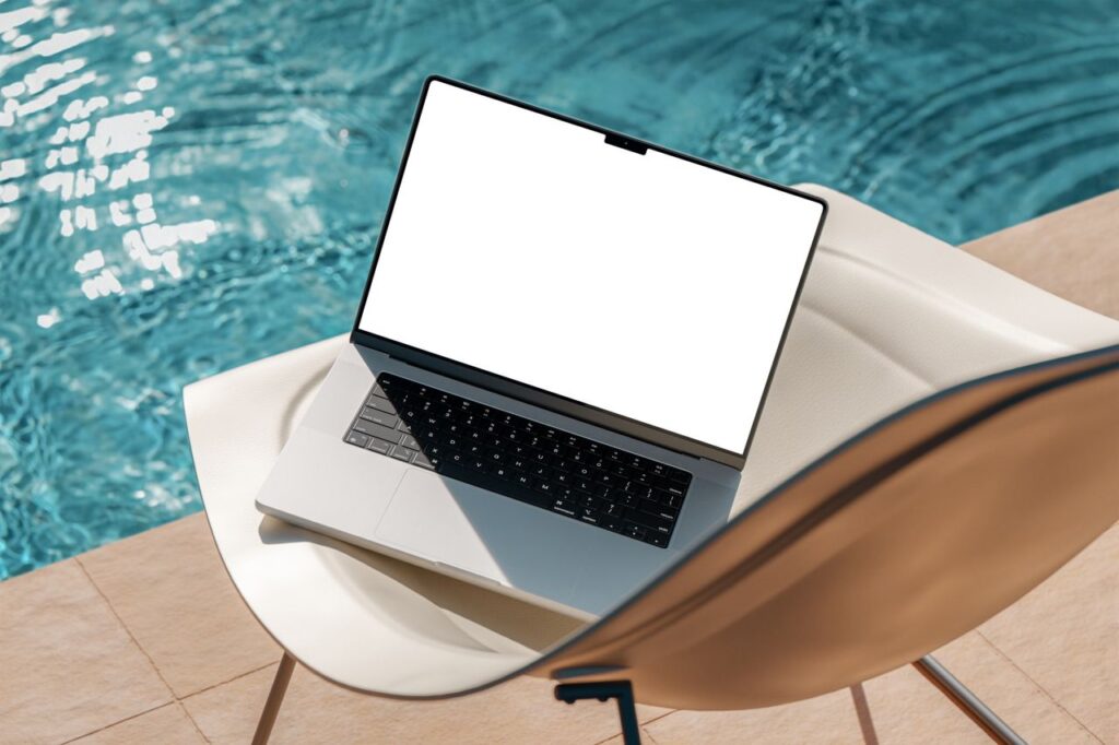 Elegant laptop with blank screen on a chair by a pool. Ideal for mockups and presentations.